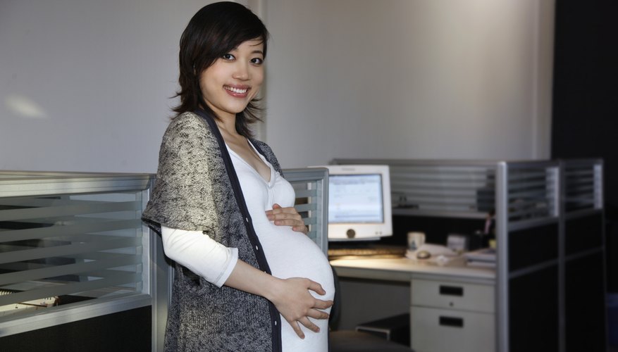 A pregnant woman is holding her stomach. A pregnant woman is holding her stomach.