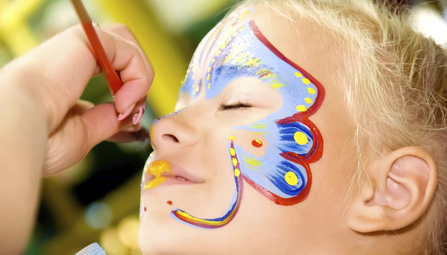 A young girl gets her face painted with a butterfly motif. A young girl gets her face painted with a butterfly motif.
