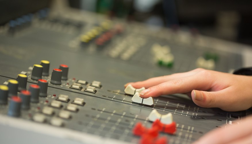 Hands working a mixing board Hands working a mixing board
