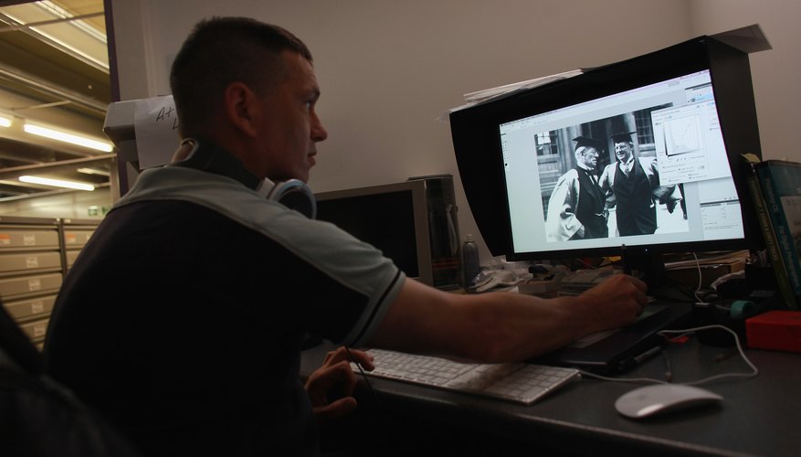 Photo Credit: Oli Scarff/Getty Images News/Getty Images Retouching damaged photo at the Hulton photo archive in England.