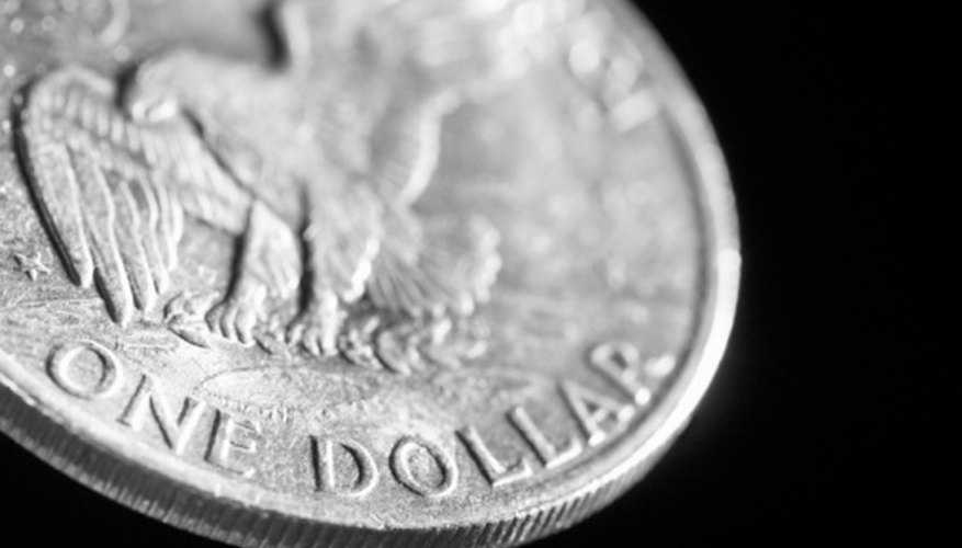 Silver dollars are often made into replicas so determining a genuine coin is important to valuing it. Silver dollars are often made into replicas so determining a genuine coin is important to valuing it.