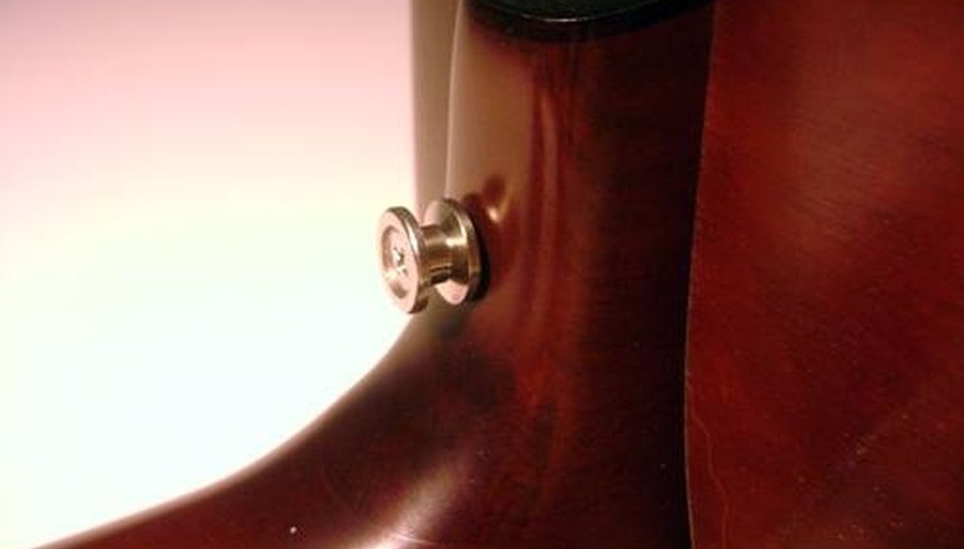 Mark your button placement halfway between the bottom of the heel and the bottom of the guitar's neck. Mark your button placement halfway between the bottom of the heel and the bottom of the guitar's neck.