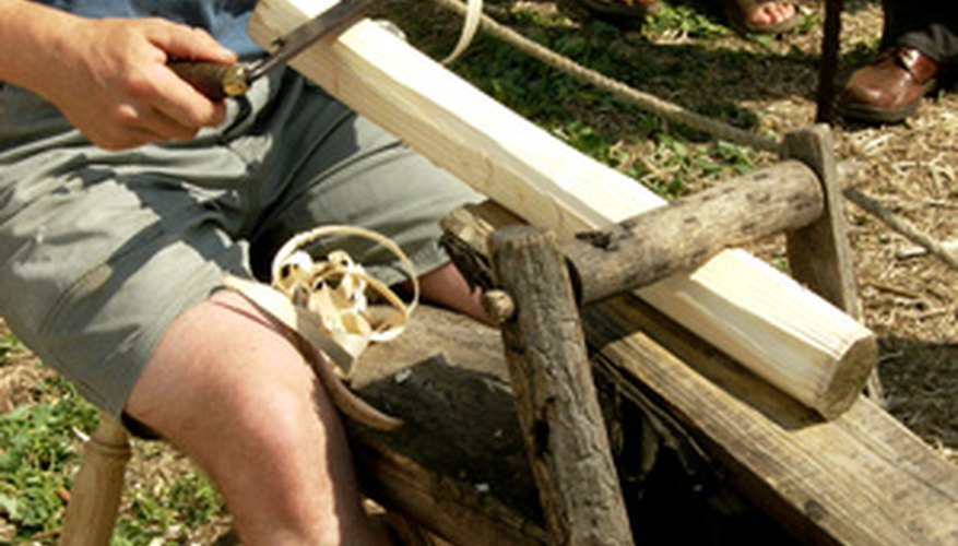 This man is using a froe to shape wood turned on a foot-powered lathe. This man is using a froe to shape wood turned on a foot-powered lathe.