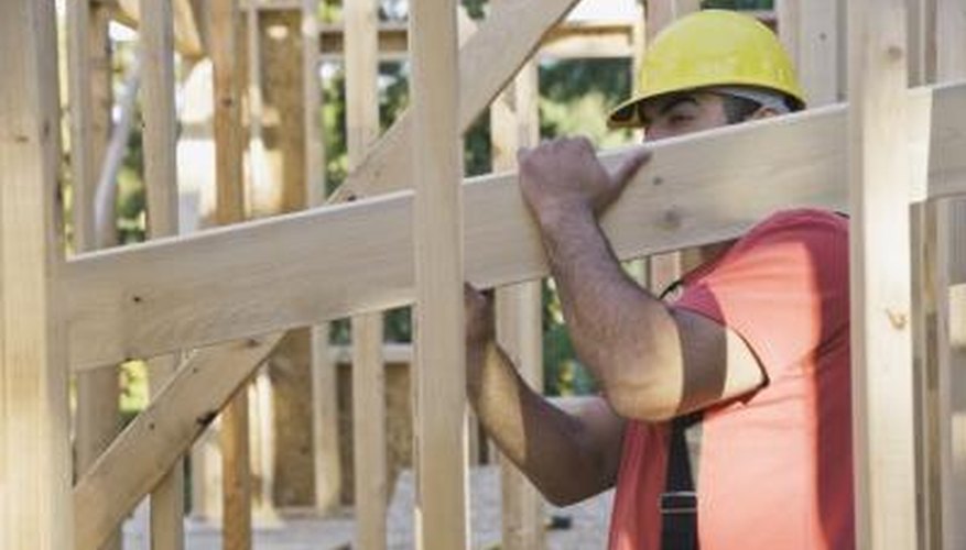 A man builds the frame of a house. A man builds the frame of a house.