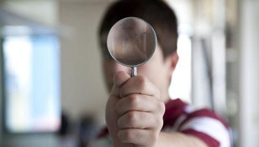 Use a magnifying glass to look closely at the painting's surface Use a magnifying glass to look closely at the painting's surface