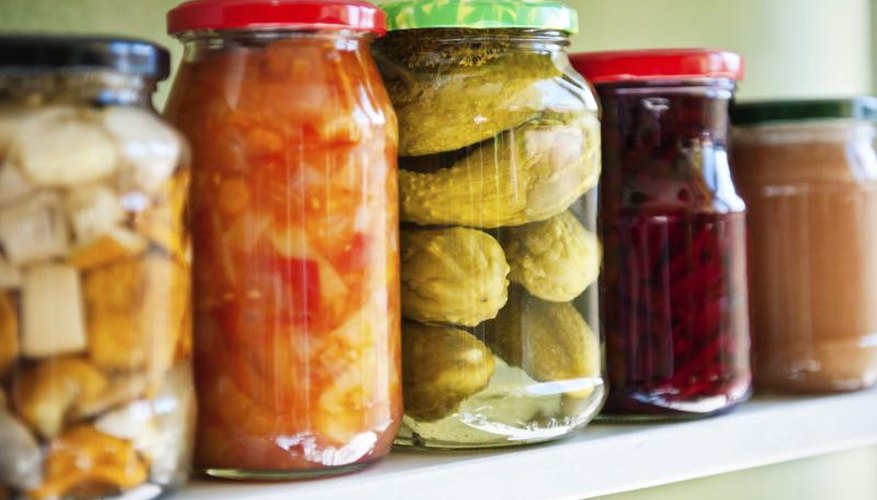 A shelf of homeade canned fruits and vegetables in a pantry. A shelf of homeade canned fruits and vegetables in a pantry.