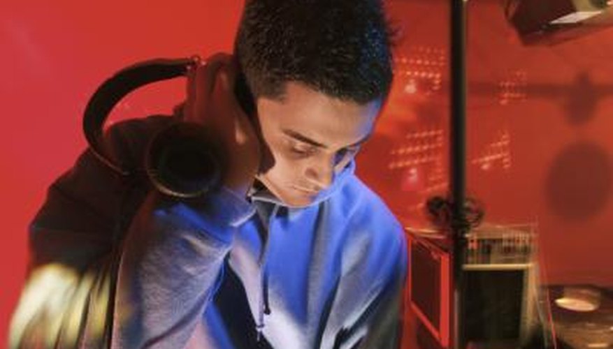 Young man listens to hip hop music while mixing new tracks Young man listens to hip hop music while mixing new tracks
