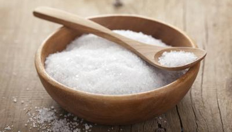 Sea Salt in wooden bowl with wooden spoon on tabletop. Sea Salt in wooden bowl with wooden spoon on tabletop.