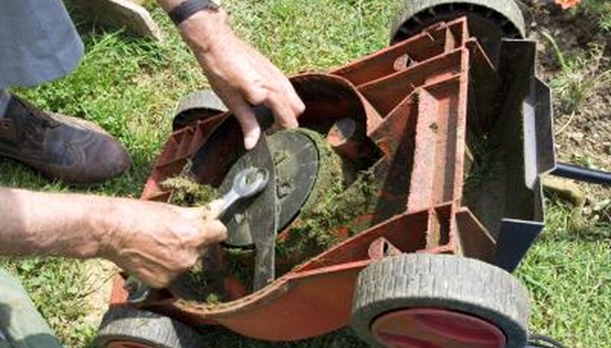 Man adjusting knife on lawnmower to help the governor. Man adjusting knife on lawnmower to help the governor.