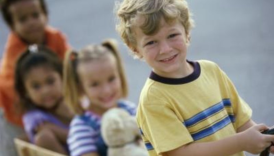 Four preschool children play with a wagon outside. Four preschool children play with a wagon outside.