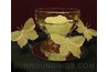 A flower candle floating in a bowl with butterflies, reflected in a mirror
