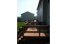 A sunny deck needs a chair and greenery.