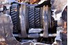 Shattered automotive gearbox / manual transmission showing gears and shifters.