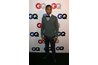 Singer Pharell Williams in a bow tie, V-neck sweater and suede boots.
