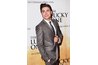Actor Zac Efron in a slender gray-taupe suit and matching charcoal gray tie