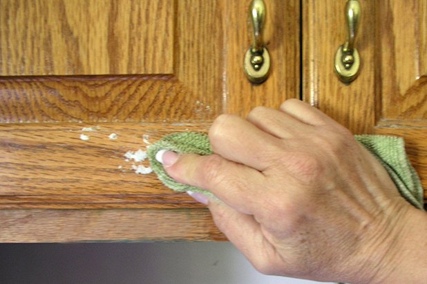 Baking soda will not scratch the cabinets.