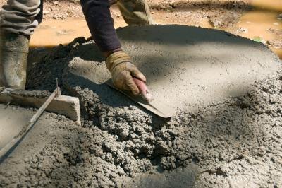 Pour concrete into holes to anchor the swing set.