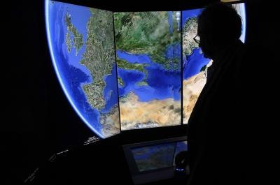 Man looking at three-dimensional rendering of planet Earth