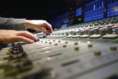Hands adjusting mix board Hands adjusting mix board