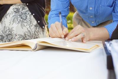 Signing guestbook with pen.