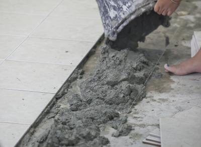 A construction worker spreads wet mortar