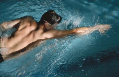 Man swimming in blue pool water