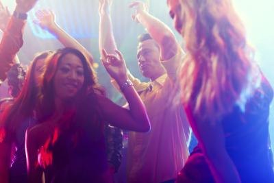 Revelers dancing on a nightclub dance floor.