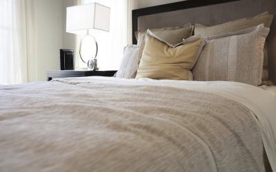 A traditional style bedroom with neutral earthy hues and textures.