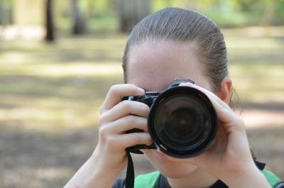 Teen girl takes photo with digital camera