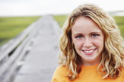 smiling woman in green barely field