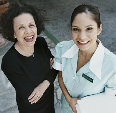 Hotel manager and maid smiling