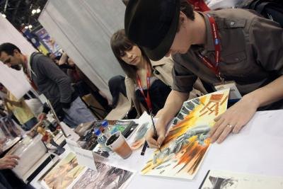A comic book artist works on a illustration at New York ComicCon