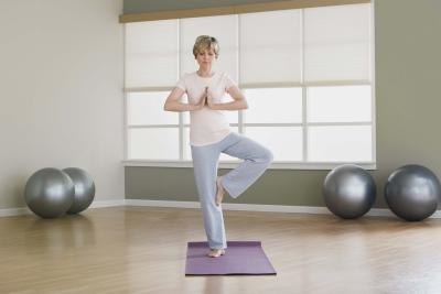 A woman balances on one foot during a yoga pose.