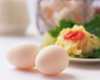 Two whole eggs in front of a salad. Two whole eggs in front of a salad.