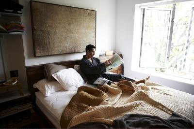 Man reading a newspaper in bed. Man reading a newspaper in bed.