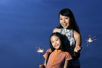 Mother supervising daughter with sparkler