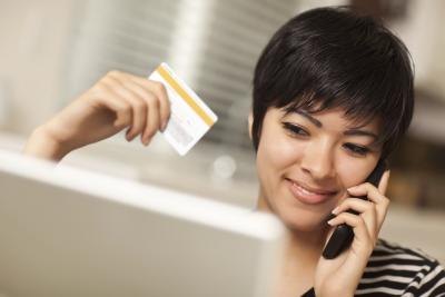 Woman on telephone holding credit card