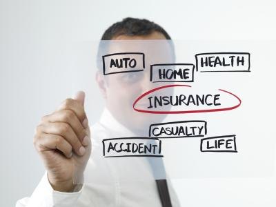 Man writing on clear surface with insurance circled in red.