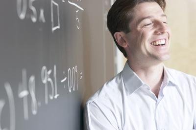 Math teacher leaning on chalkboard