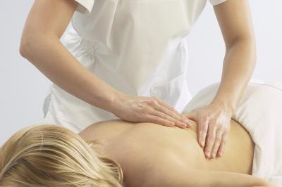 a woman receives a massage to cope with a pinched nerve. a woman receives a massage to cope with a pinched nerve.