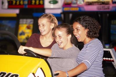 Teenage girls playing arcade game