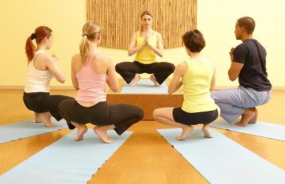 A yoga class does prayer squat.