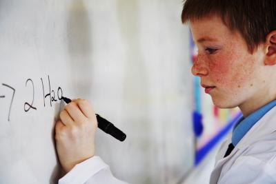 Student writing on a whiteboard.