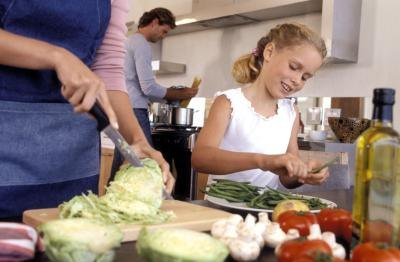 Daughter helping mother in kitchen