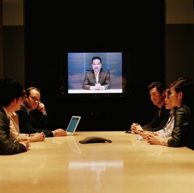 Employees meet in the conference room for a webinar.