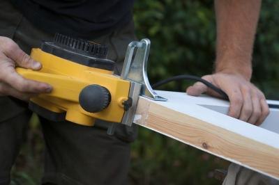Carpenter using electric plane Carpenter using electric plane