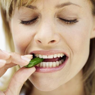 Woman biting into green chili