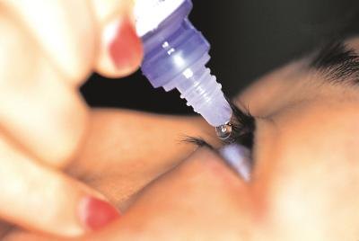 woman using Naphcon-A eyedrops