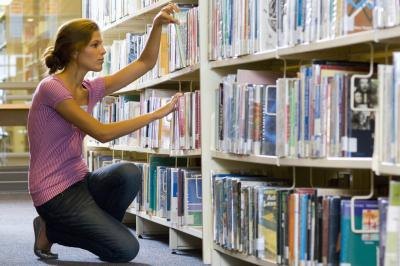 Woman looking for book in library.
