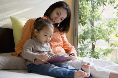 Mother reading with child in bed